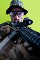 Image showing soldier in action aiming laseer sight optics green background