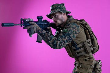 Image showing soldier in action aiming laseer sight optics pink background