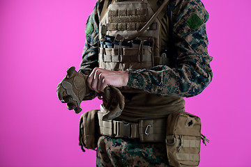 Image showing closeup of soldier hands putting protective battle gloves pink b