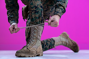 Image showing soldier tying the laces on his boots