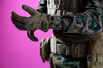 Image showing closeup of soldier hands putting protective battle gloves pink b