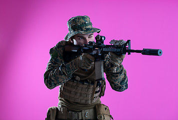 Image showing soldier in action aiming laseer sight optics pink background