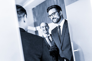 Image showing Group of confident business people greeting with a handshake at business meeting in modern office or closing the deal agreement by shaking hands.