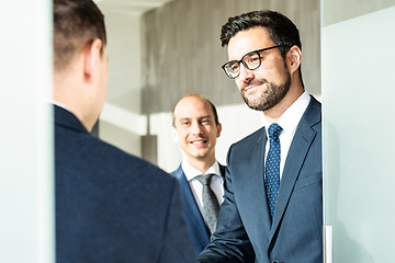 Image showing Group of confident business people greeting with a handshake at business meeting in modern office or closing the deal agreement by shaking hands.