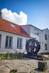 Image showing Water mill with flowers on a terrace in a backyard