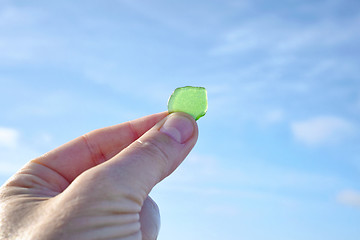 Image showing Hand holding green sanded glass