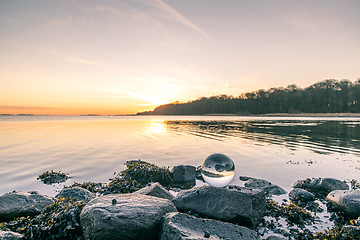 Image showing Glass orb on o rock by the lake