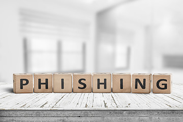 Image showing Phishing scam sign on a wooden table