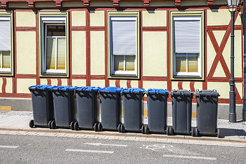 Image showing Garbage bins on the street outside an old house