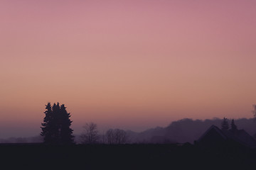 Image showing Violet morning sunrise over rooftops