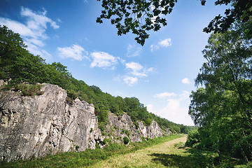 Image showing Green meadow in a valley with cliffs