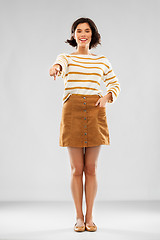 Image showing woman in pullover, skirt and shoes pointing to you