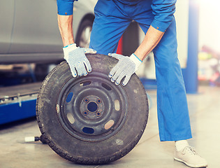 Image showing mechanic with wheel tire at car workshop