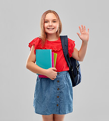 Image showing happy student girl with books and bag waving hand