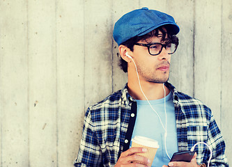 Image showing man with earphones and smartphone drinking coffee