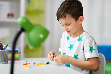 Image showing little boy playing with building kit at home