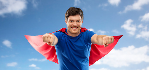 Image showing man in red superhero cape over sky background