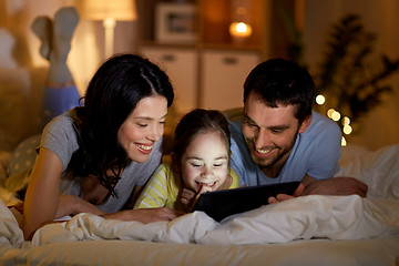 Image showing family with tablet pc in bed at night at home