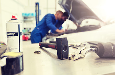 Image showing working tools and men repairing car at workshop