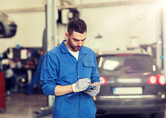 Image showing auto mechanic man with clipboard at car workshop