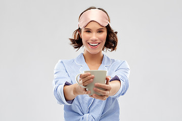 Image showing woman in pajama and sleeping mask drinking coffee