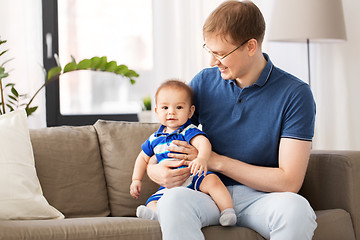 Image showing happy father with baby son sitting on sofa at home