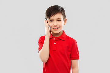 Image showing smiling boy in red t-shirt calling on smartphone