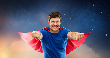 Image showing man in red superhero cape over night sky