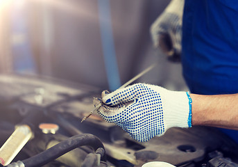 Image showing mechanic with dipstick checking motor oil level