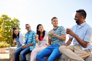 Image showing friends drinking coffee and juice talking in city