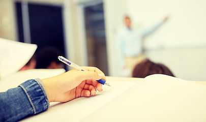 Image showing student hand writing to notebook at lecture