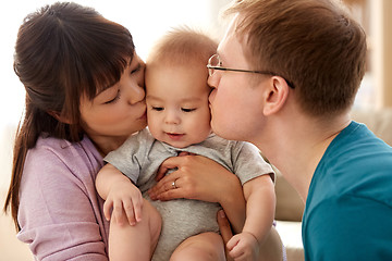 Image showing happy mother and father kissing baby son at home