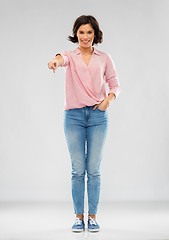 Image showing young woman in shirt and jeans pointing to you