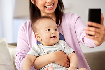 Image showing asian mother with baby son taking selfie at home