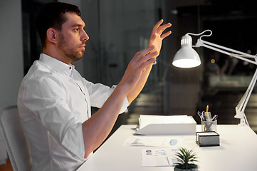 Image showing businessman using gestures at night office