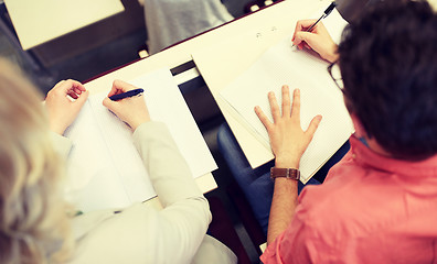 Image showing students writing to notebooks at exam or lecture