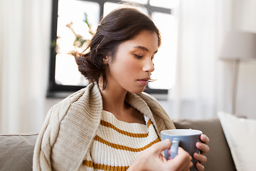 Image showing sad sick young woman drinking hot tea at home