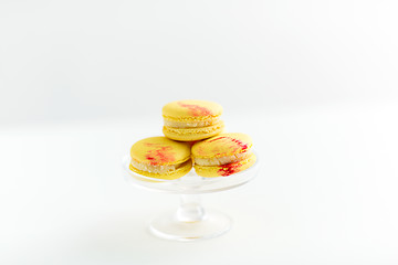 Image showing lemon yellow macarons on glass confectionery stand