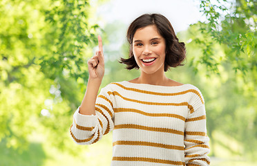 Image showing happy woman showing one finger or pointing up