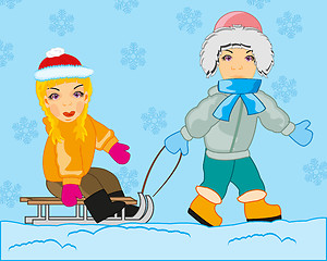 Image showing Boy rolls girl on sled in winter