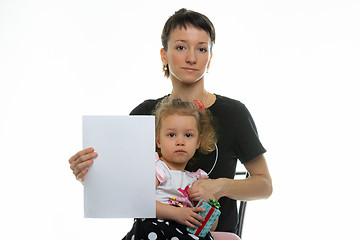 Image showing Mom and baby sit on a chair and hold a white sheet in their hands