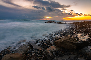 Image showing Waves roll on rocky shore during storm