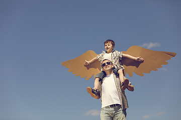 Image showing Father and son playing with cardboard toy wings