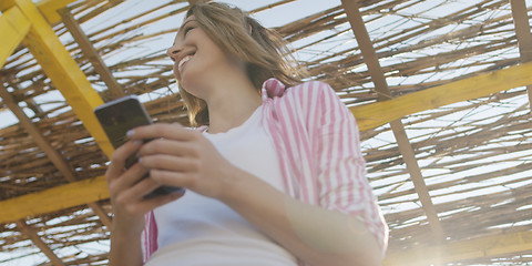 Image showing Smartphone Woman Texting On Cell Phone At Beach