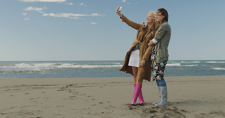 Image showing Girls having time and taking selfie on a beach