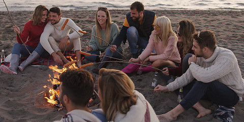 Image showing Group Of Young Friends Sitting By The Fire at beach