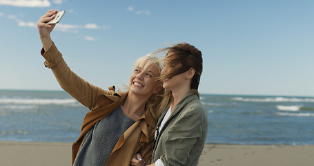 Image showing Girls having time and taking selfie on a beach