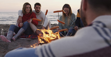 Image showing Group Of Young Friends Sitting By The Fire at beach