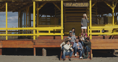 Image showing Group of friends having fun on autumn day at beach