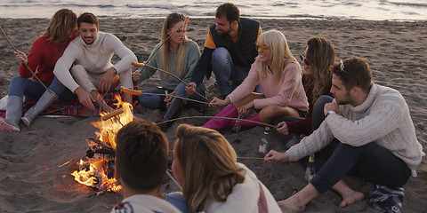 Image showing Group Of Young Friends Sitting By The Fire at beach